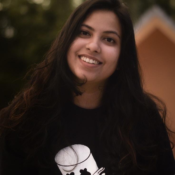 Kaveri Mehta, Lead Design Curator at Quiet Paper Harbor, reviewing corporate floral arrangements